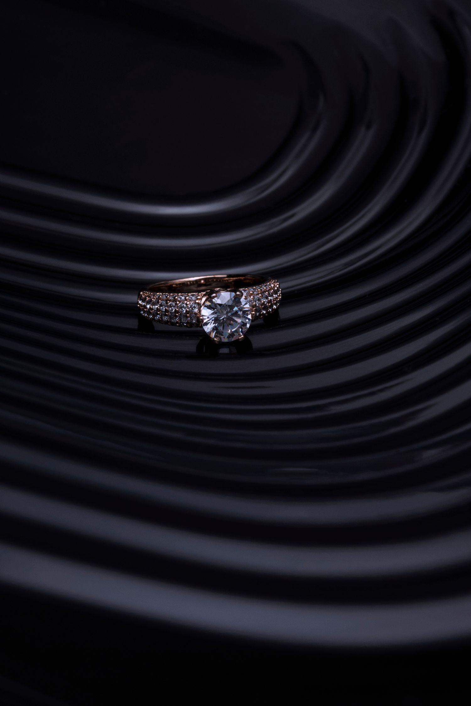Bague solitaire en or, diamant taille brillant, macro sur drapé noir
